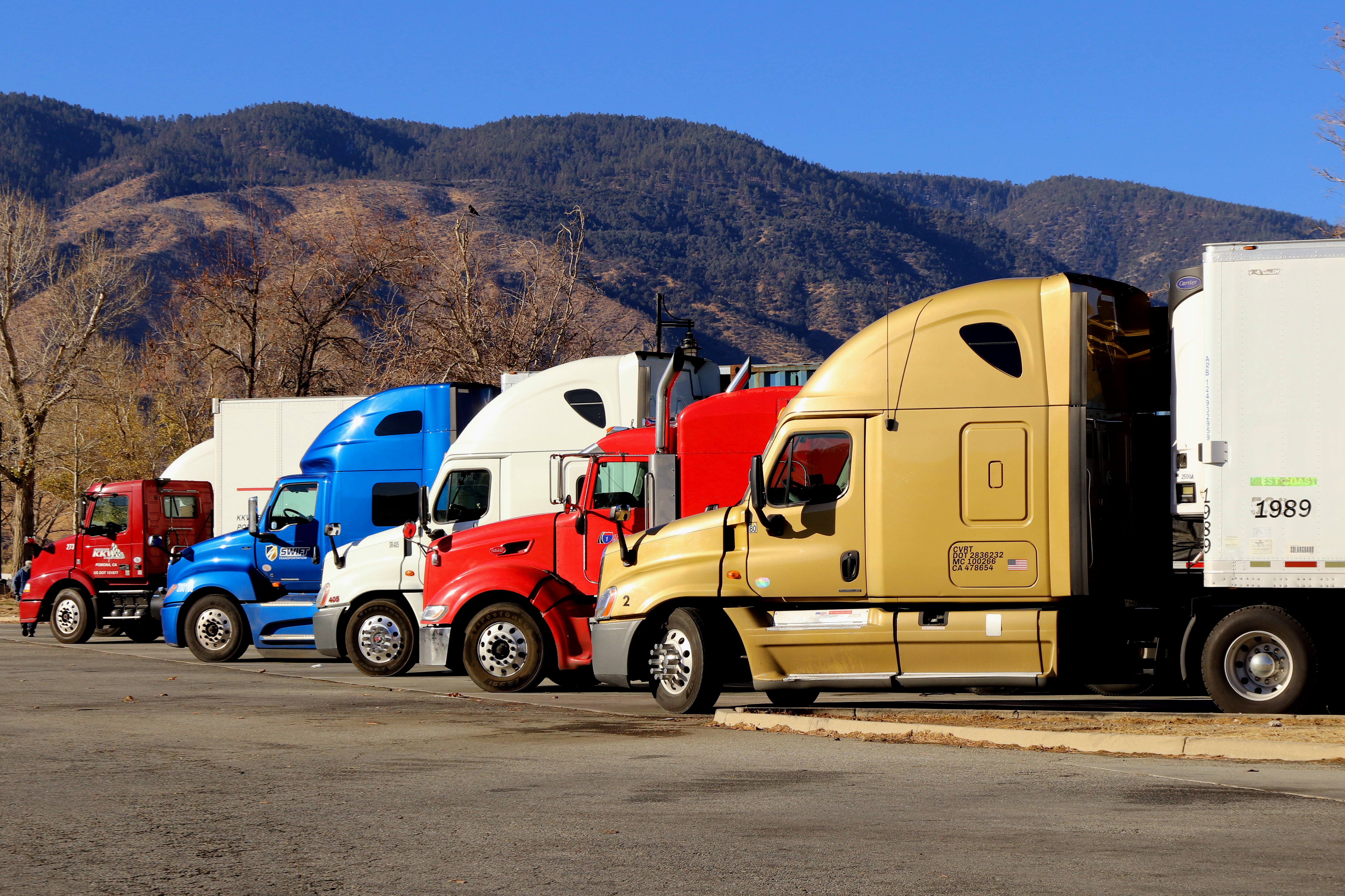 5 different colored semi trucks