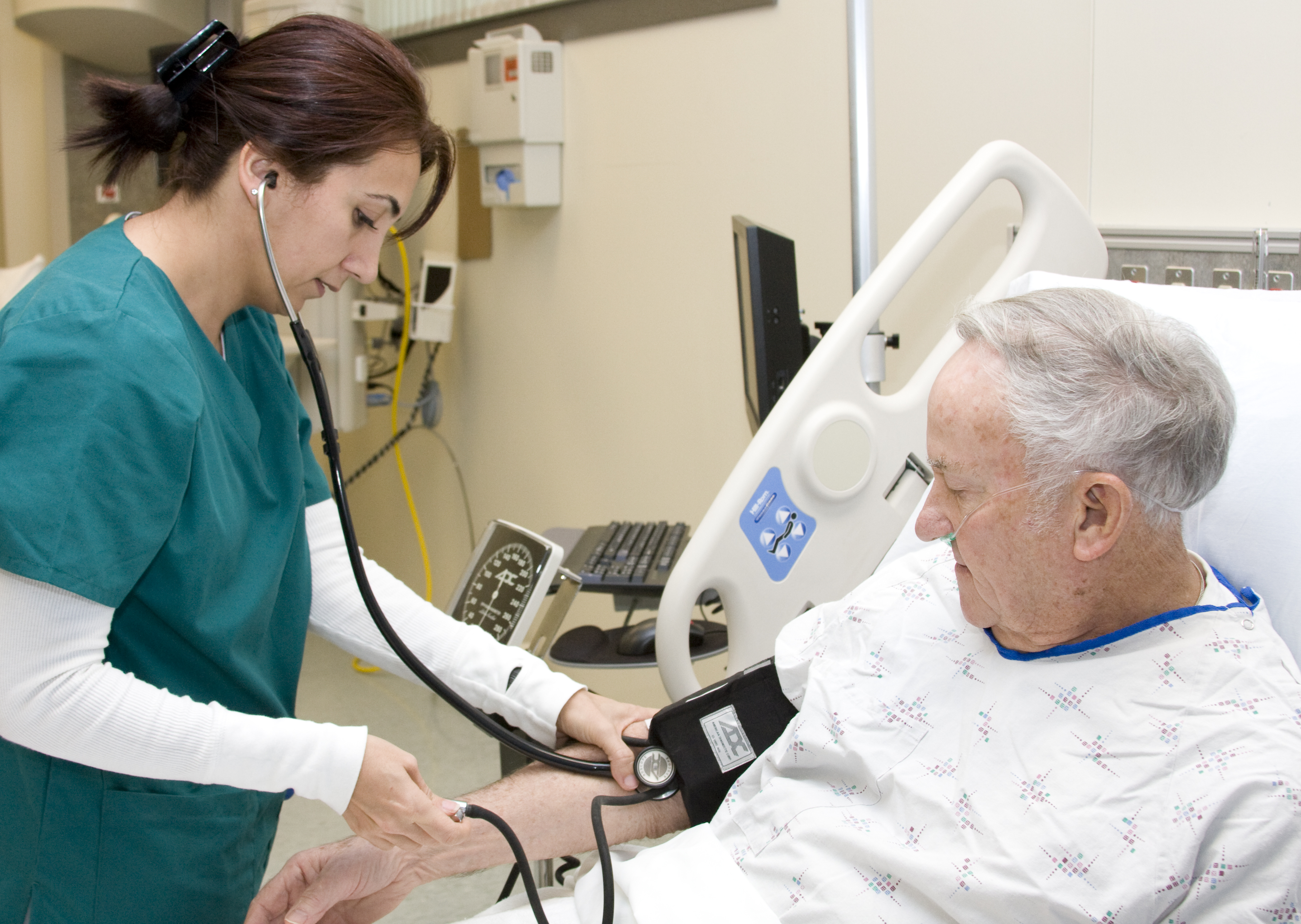Nurse checking pulse of older patient. 