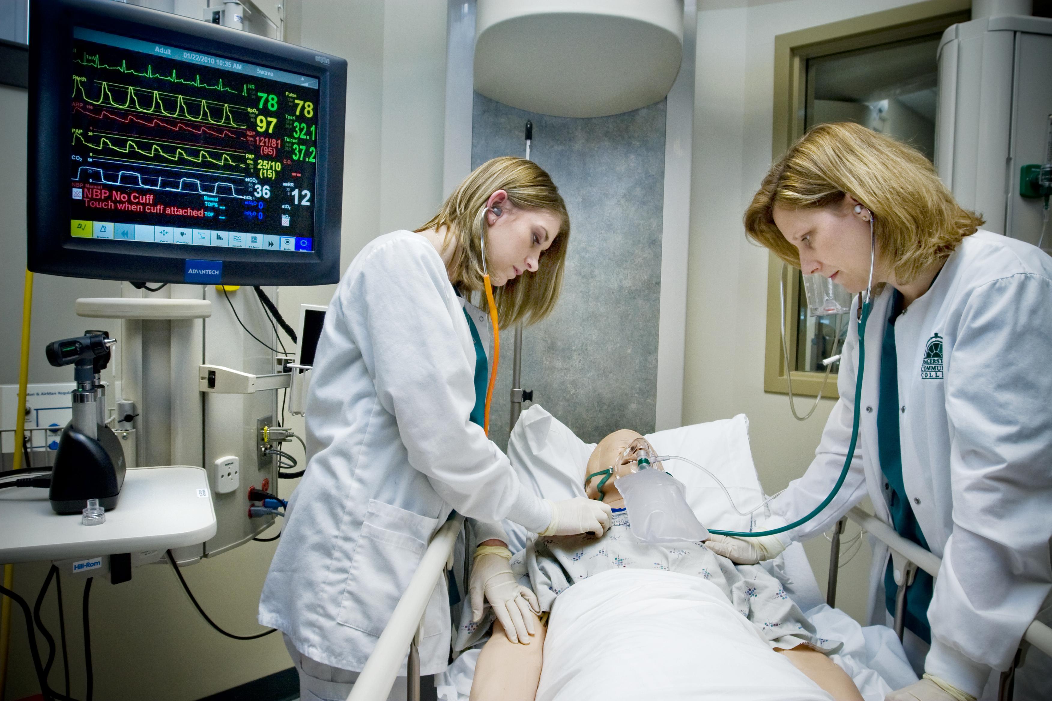 Two healthcare workers working on a dummy