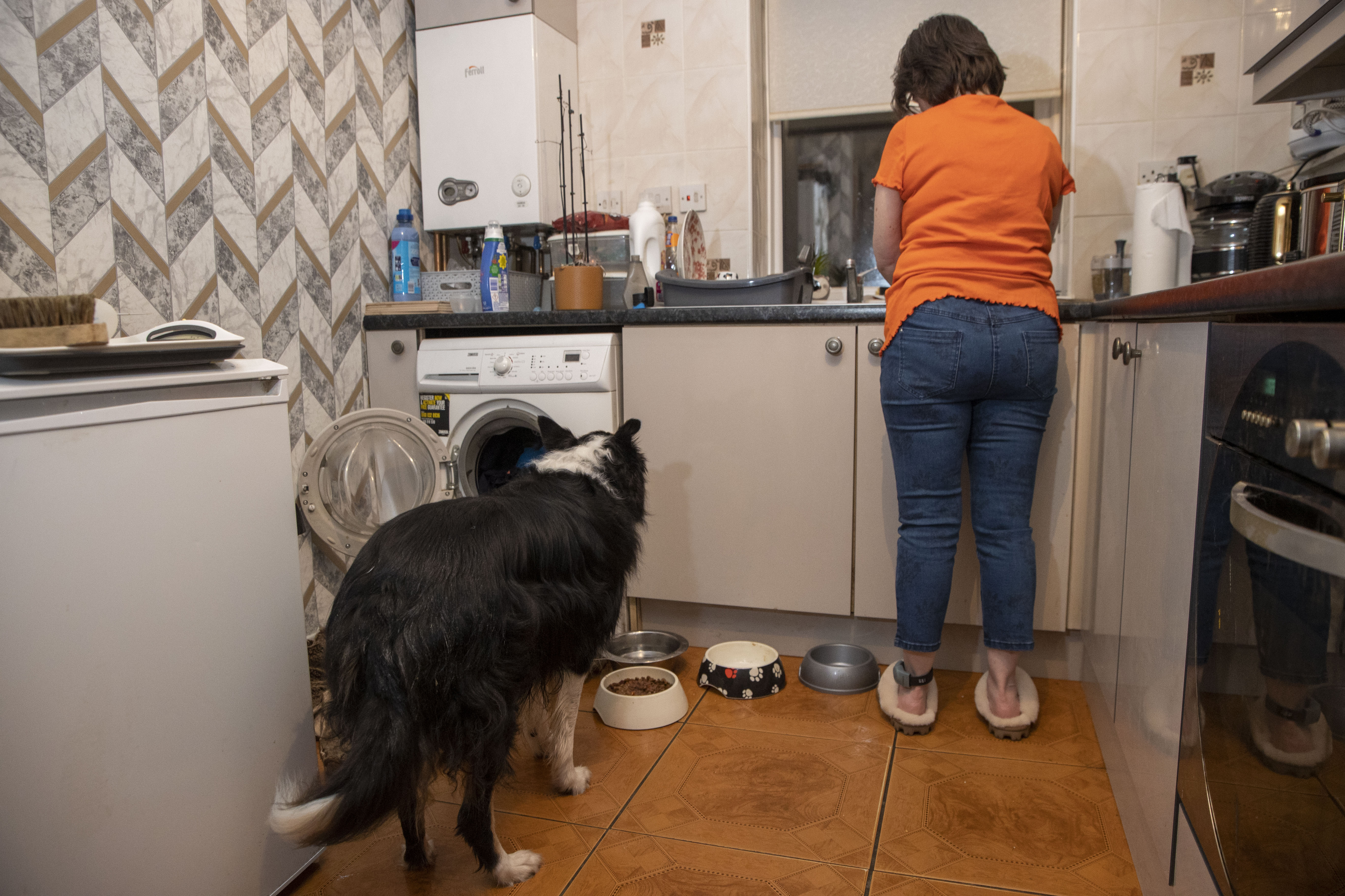 Person in kitchen wearing ankle monitor