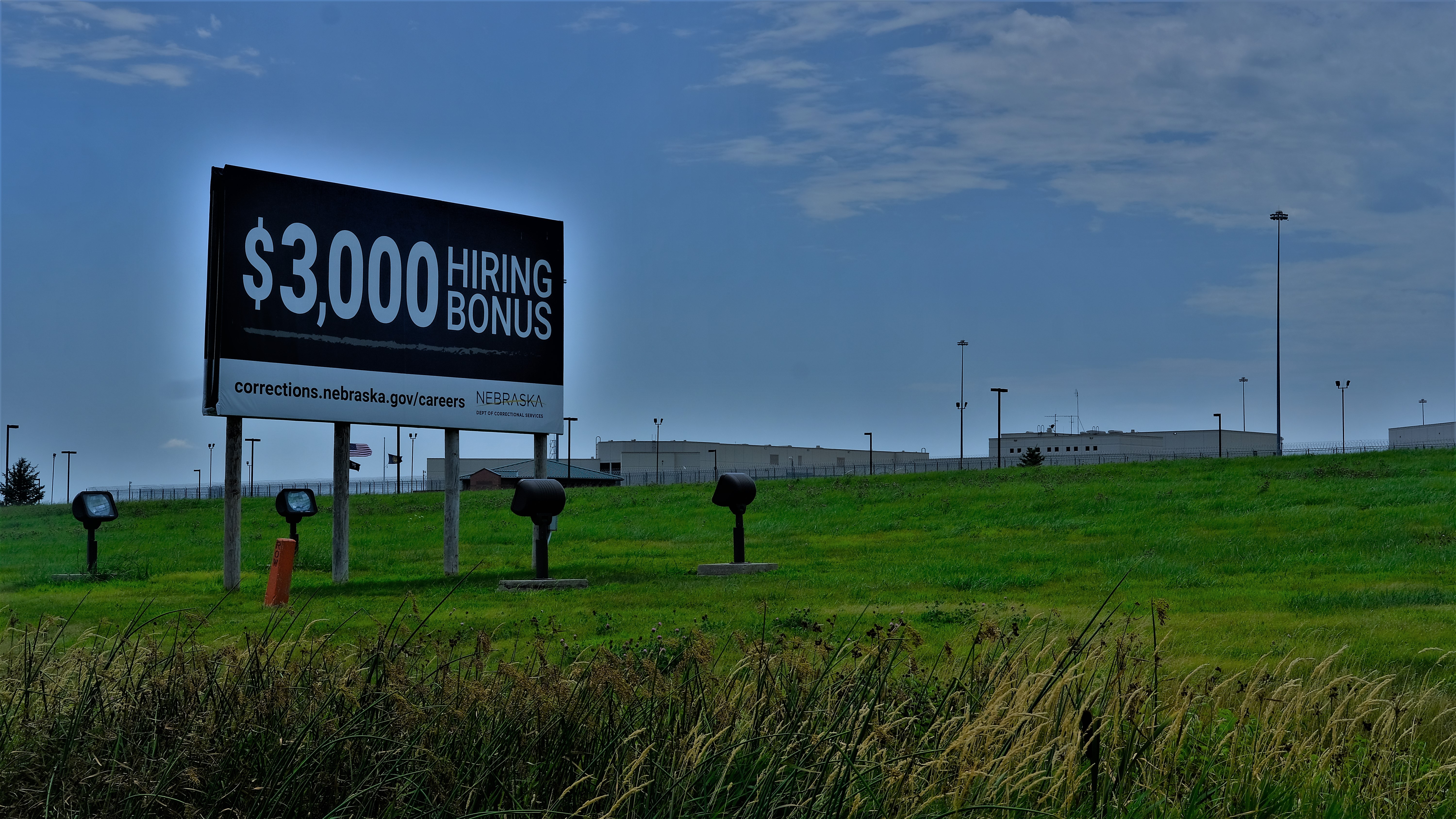 Billboard outside prison advertising opportunities for hiring prison employees. 