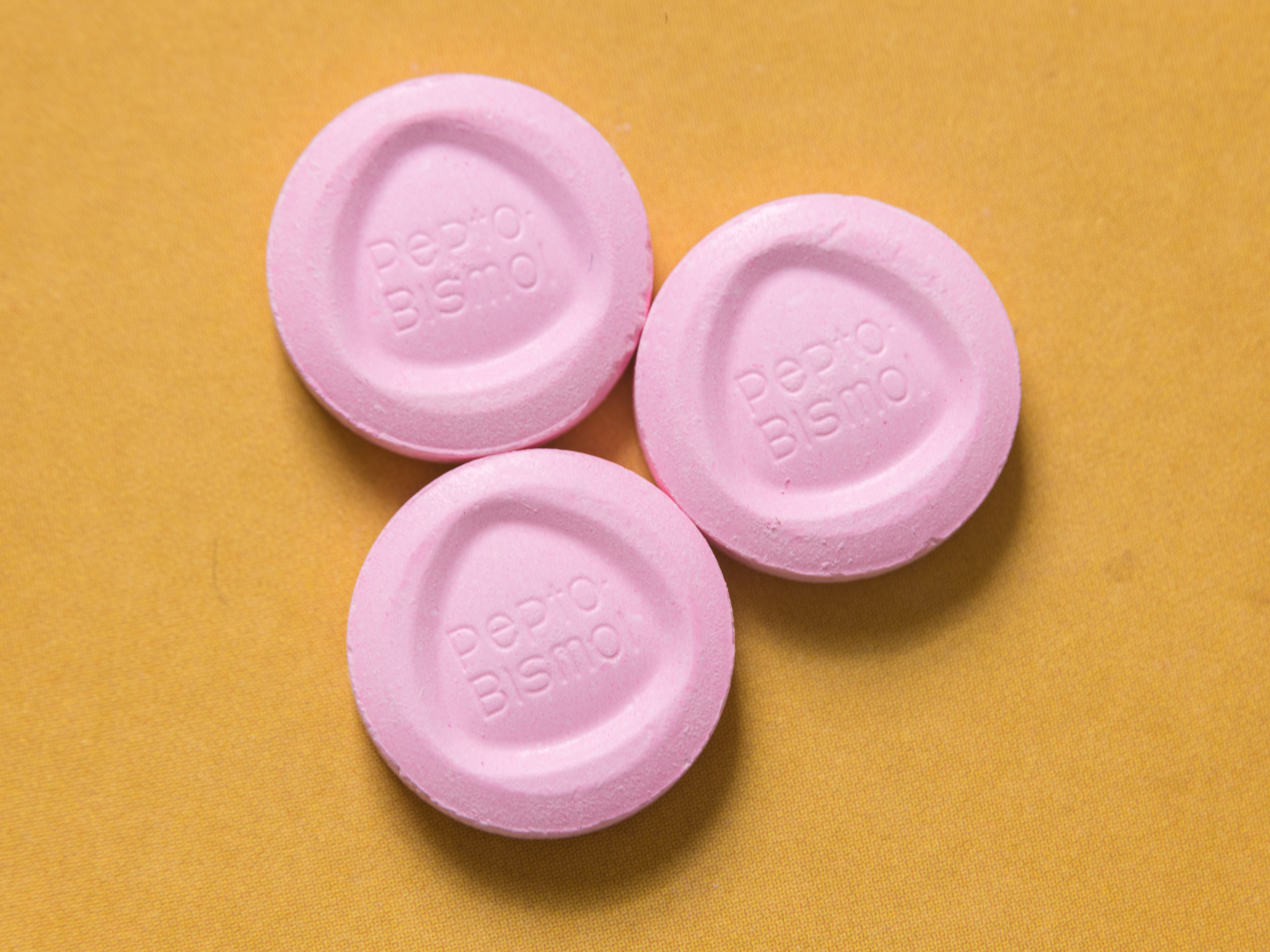 3 pink pills branded Pepto Bismol