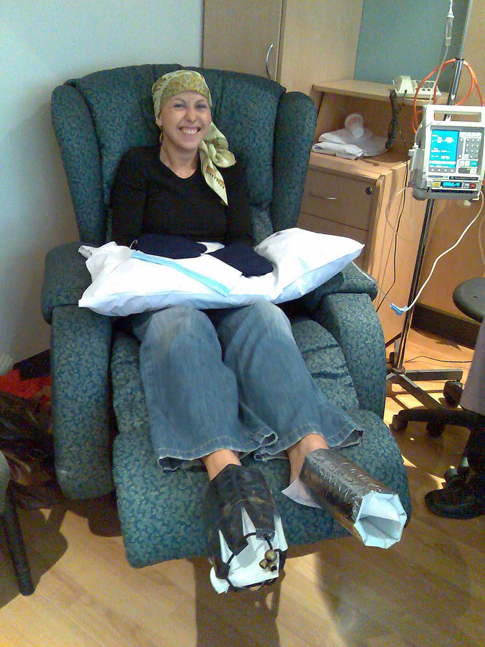 Smiling woman receiving chemo treatment wearing accral cooling devices 