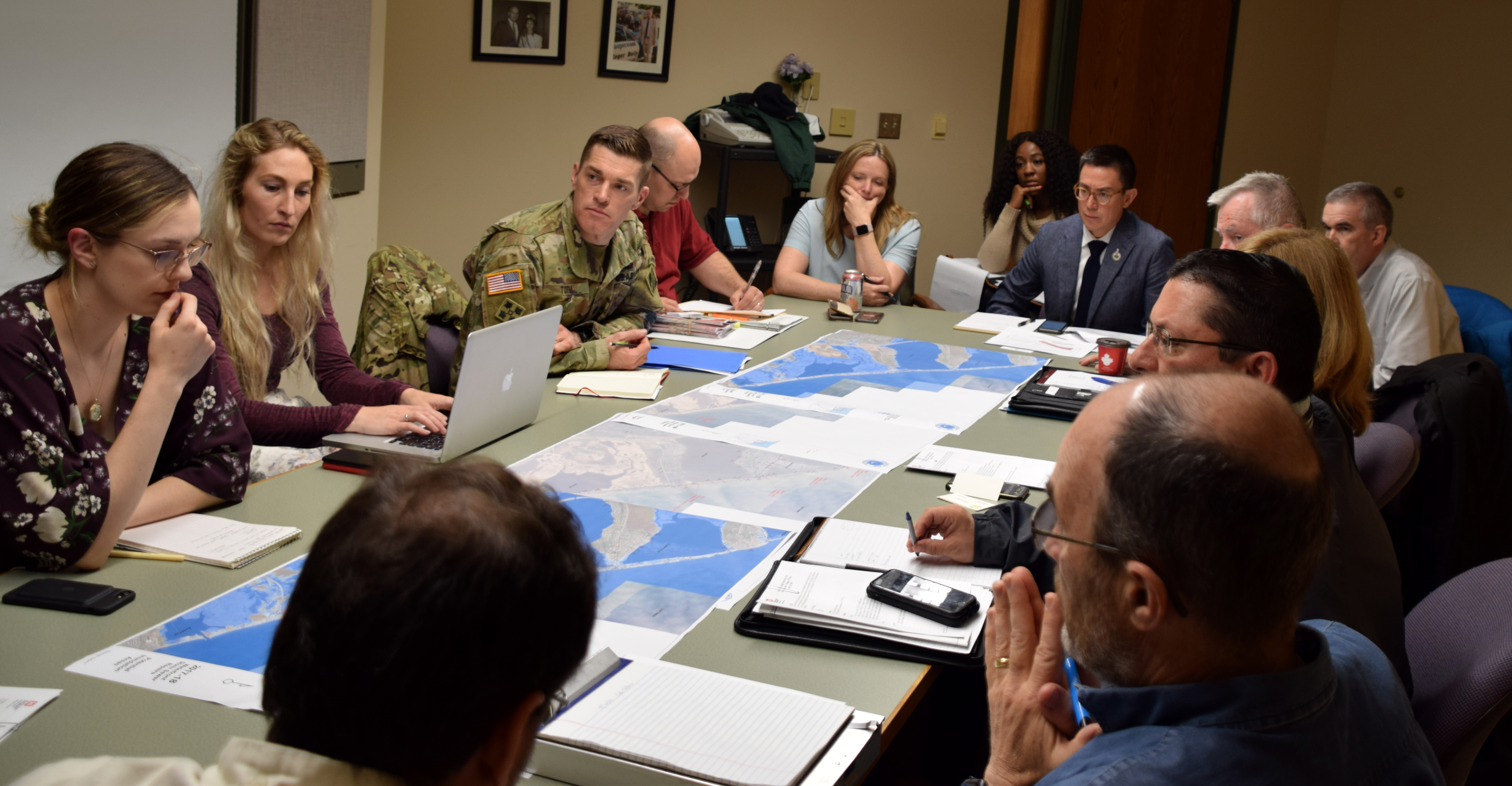 People around a table looking at flood maps