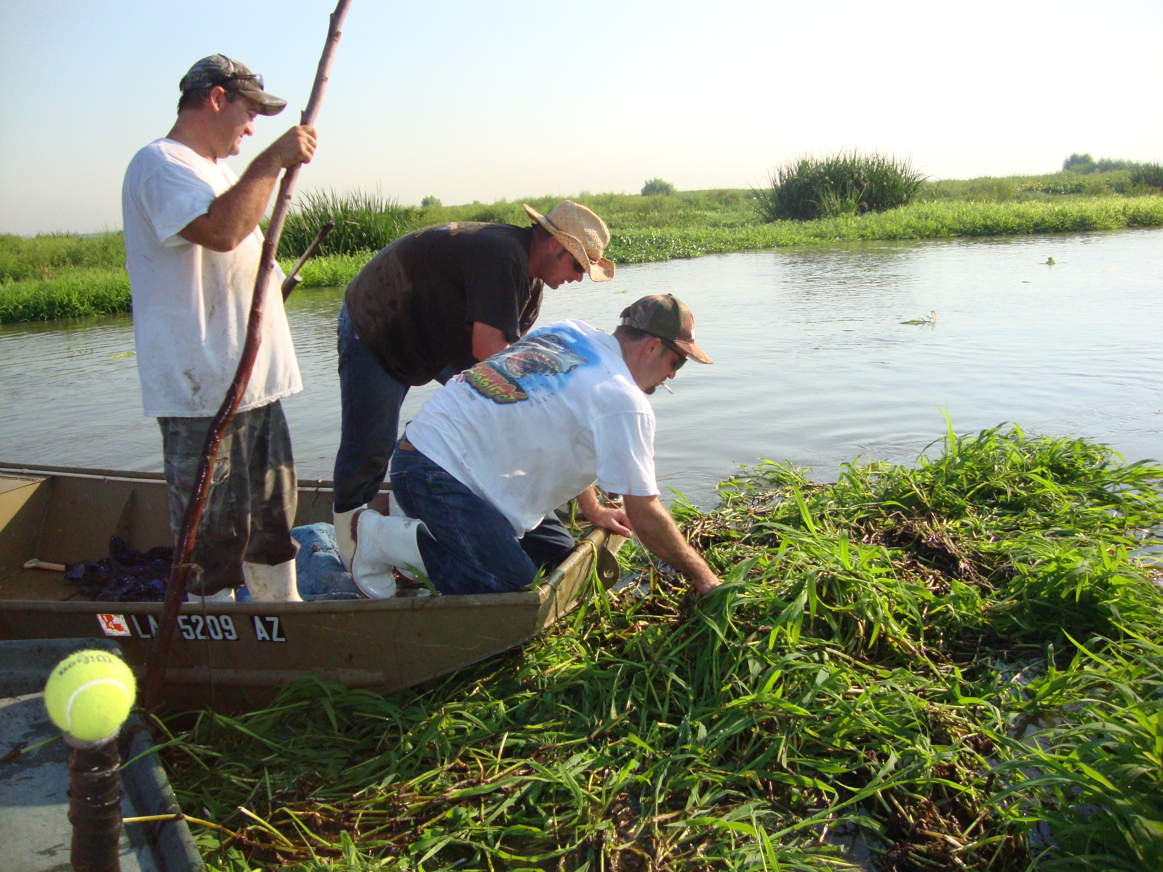 Three men in a boat hunting alligators in Louisiana